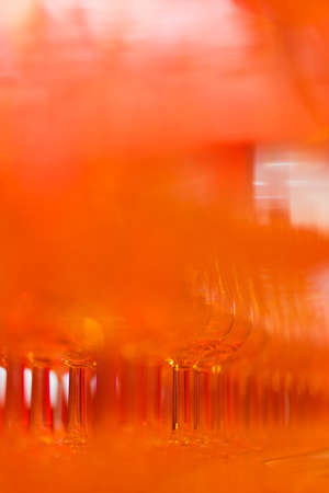 Empty classic whiskey glasses on the bar in a bright red glowの写真素材