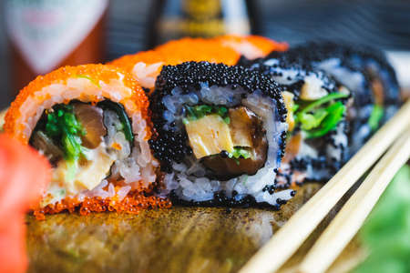 Set of traditional Japanese rolls Philadelphia and California on a plate with wooden chopsticksの写真素材