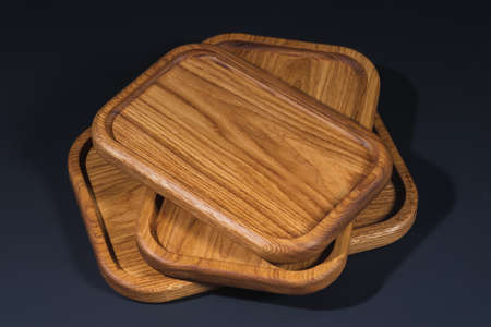 Wooden stylish cutting boards for the kitchen on a black background.の写真素材