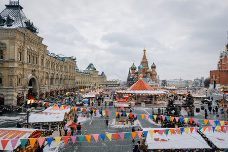 January, 2022 - Moscow, Russia, Red Square: Bright New Year and Christmas fair with a carousel and souvenirs and treats shop. Tourists and guests of the city are walking on the square.のeditorial素材