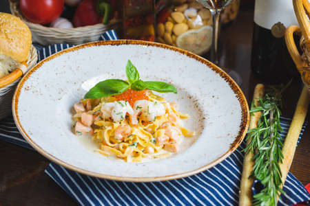 Traditional Italian pasta Carbonara with salmon and red caviar on a plateの写真素材