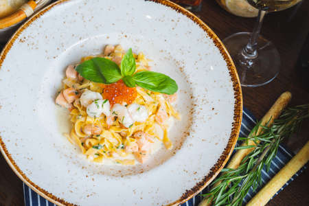 Traditional Italian pasta Carbonara with salmon and red caviar on a plateの写真素材