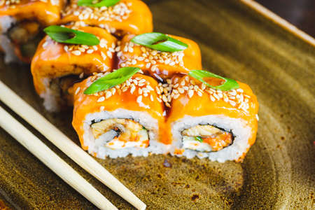 Traditional Japanese rolls with salmon fish, eel, seafood on a plate with wooden chopsticksの写真素材