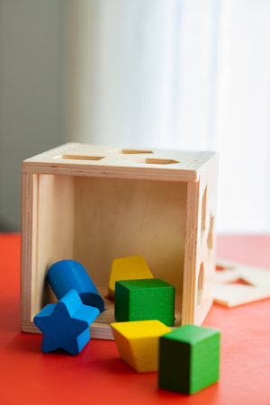 Wooden toy blocks on a red table in a children's roomの写真素材