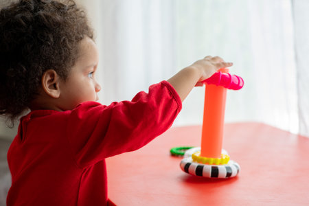 Cute latin american little girl playing with toys at homeの写真素材