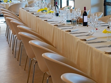 long  restaurant table prepared with wine water  glasses napkins and silver waresの写真素材