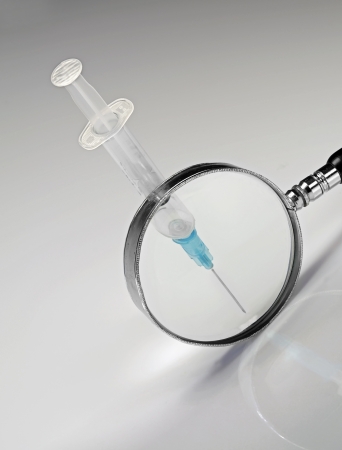 pay attention  the needle of a syringe  is pointed, white backgroundの写真素材