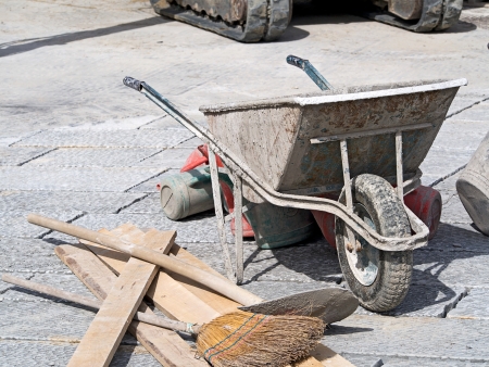 paving work with wheelbarrow bucket and broomの写真素材