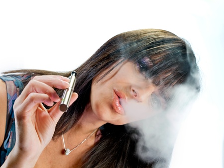 brunette beautiful girl smoking electronic cigaretteの写真素材