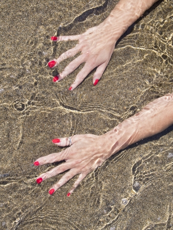 woman hands on the water foreshore,  black sand
の写真素材