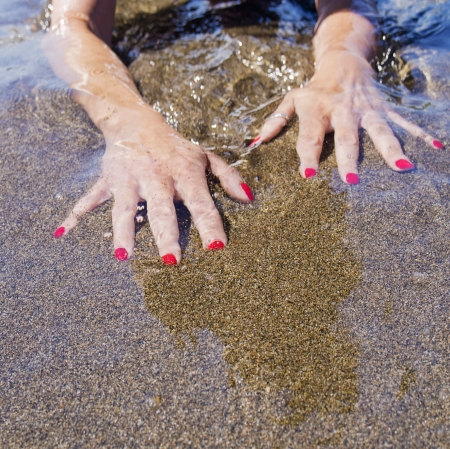 woman hands on the water foreshore,  black sand
の写真素材