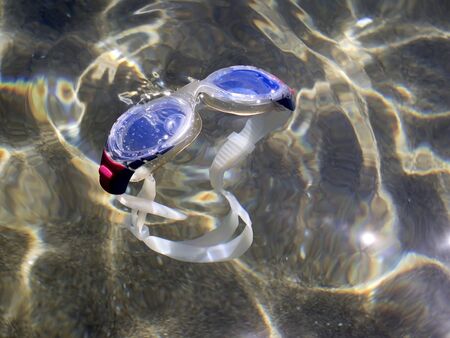 swimming goggles floating on foreshore in the seaの写真素材