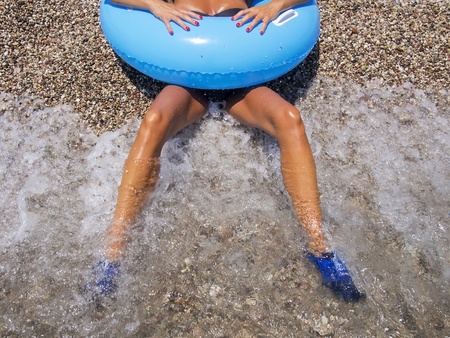 two beautiful tanned woman's legs on the shore washed byの写真素材