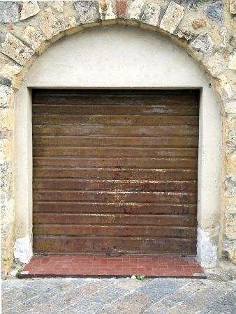 rusty shop rolling portcullis of stone house is closedの写真素材