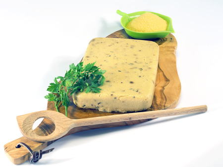hardened polenta on a wooden olive chopping board  の写真素材