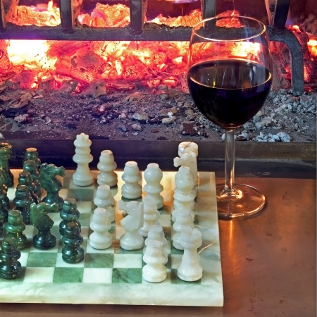 play chess drinking red wine in front of a roaring fireplaceの写真素材