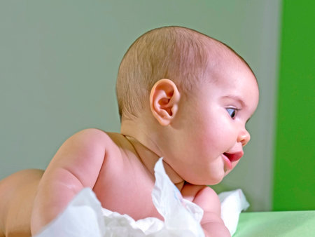baby girl   intense eyes smiling and wondering  on the changing table