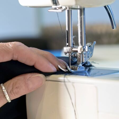 hand of  woman working cloth with  old sewing machineの写真素材
