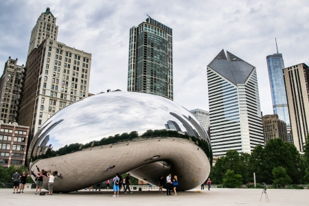 Chicago,USA-august 12,2013 Tourists take pictures and admire the skyline of chicago through the famous monument  Cloud Gate  in the Millennium Parkのeditorial素材
