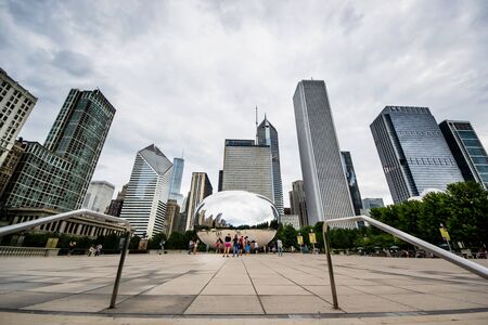Chicago,USA-august 12,2013 Tourists take pictures and admire the skyline of chicago through the famous monument  Cloud Gate  in the Millennium Parkのeditorial素材