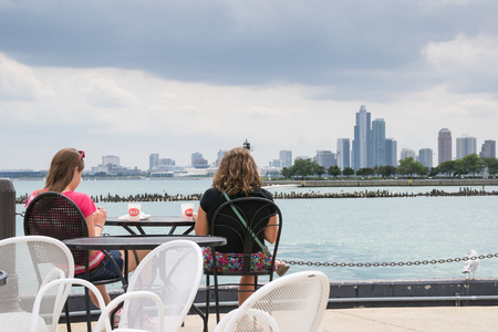 Chicago,USA-august 12,2013 two girls sitting at the bar resting and drink while admiring the skyline of Chicago on a cloudy dayのeditorial素材