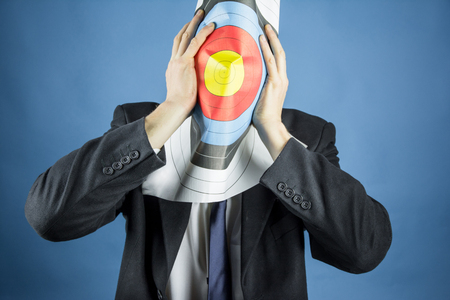 business man holding a target on her faceの写真素材
