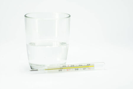 thermometer near a cup of water with aspirinの写真素材