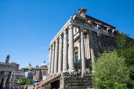 rome,italy-April 17,2014 tourists stroll admiring the Temple of Antoninus Pius and Faustinaof in the Roman Forum in a sunny day in Romeのeditorial素材
