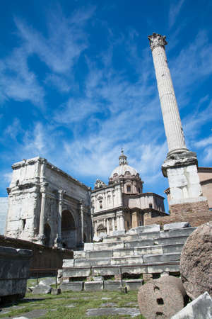 tourists stroll admiring the majesty of the Roman Forum in a sunny day in Romeの写真素材
