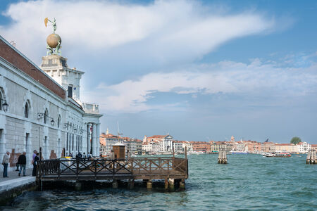 Venice,Italy- May 1,2014 - Tourist stroll near of the more Venetian canal with his boats and houses during a sunny dayのeditorial素材