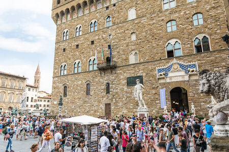 Florence,Italy-august 26,2014:many tourists in Piazza della signoria take pictures, buy souvenirs or enter in the Palazo vecchio during a sunny day.Palazzo vecchio in one of the symbols of Florence.のeditorial素材