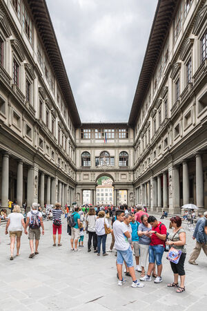 Florence, Italy ? August 26,2014:Many tourists strolling in the Uffizi gallery in the middle of the street artist or to go to the museums during a cloudy day.のeditorial素材