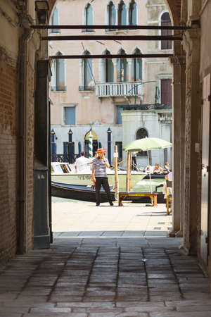 Venice,Italy-August 12,2014:a gondolier waiting some tourist to carry around the canal in Venice during a sunny dayのeditorial素材
