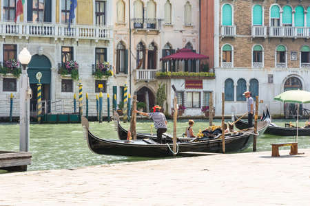 Venice,Italy-August 12,2014:Venetian gondoliers await some tourists to carry around on a gondola in Venice During a sunny day.のeditorial素材