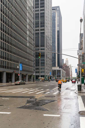 new York City, USA - August 2, 2013:Urban view of  the cyclist run between the skyscrapers of New York during a cloudy day.のeditorial素材