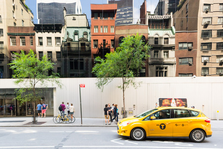 new York City, USA - August 3, 2013:Classic yellow taxy in front of the entrance to the Moma, the famous museum of modern art in New York during a sunny day.のeditorial素材
