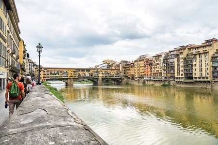 Florence,Italy-August 26,2014:view of tourist near the famous ponte vecchio over the river Arno during a cloudy day in  Florence-Italy.のeditorial素材