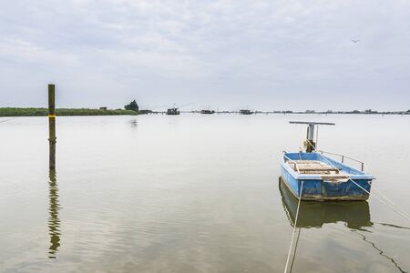 Old fishing boats moored in a swamp during a cloudy dayの写真素材