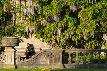 Salzburg,Austria-May 10,2015:people are in rest on the bench inside the famous Mirabell gardens in Salzburg during a sunny day.のeditorial素材