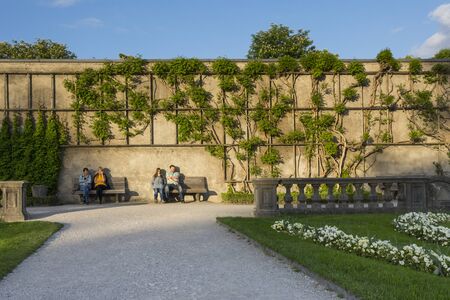 Salzburg,Austria-May 10,2015:people are in rest on the bench inside the famous Mirabell gardens in Salzburg during a sunny day.のeditorial素材