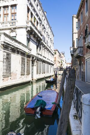 Venice,Italy-August 12,2014:Venetian gondoliers carry around some tourists  on a gondola in Venice During a sunny day inside her famous canals.のeditorial素材