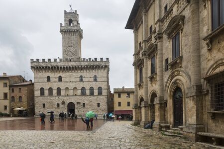Montepulciano,Italy-April 23,2016:people stroll under the rain in the town square of Montepulciano during a cloudy day.のeditorial素材