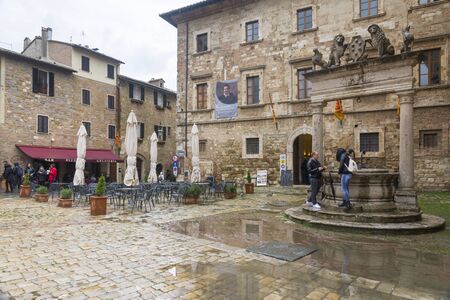 Montepulciano,Italy-April 23,2016:people stroll under the rain in the town square of Montepulciano during a cloudy day.のeditorial素材