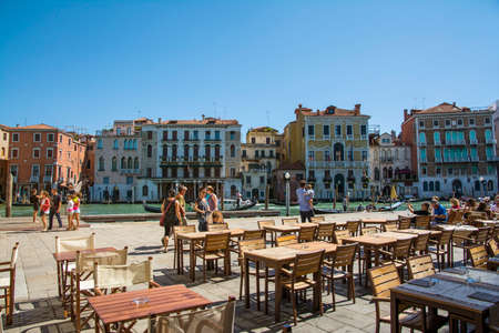 Venice,Italy-August 17,2014:people stroll or take a rest near the bar and restaurant on Grand canal near the Rialto bridge  during a sunny day.のeditorial素材
