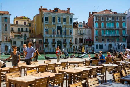 Venice,Italy-August 17,2014:people stroll or take a rest near the bar and restaurant on Grand canal near the Rialto bridge  during a sunny day.のeditorial素材