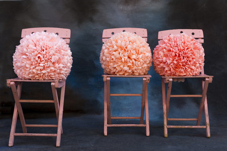 Pink chairs with pink pom poms on a blue backgroundの写真素材