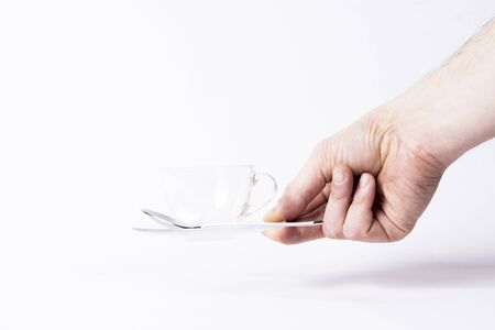 a hand rests a empty ant transparent cup of coffee on white background .の写真素材