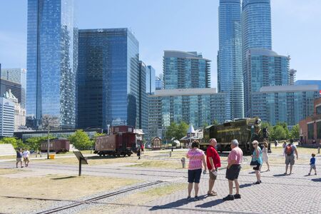 Toronto,Canada-august 2,2015:people visit the  Toronto's railway heritage center with a view of skyscrapers during a sunny dayのeditorial素材