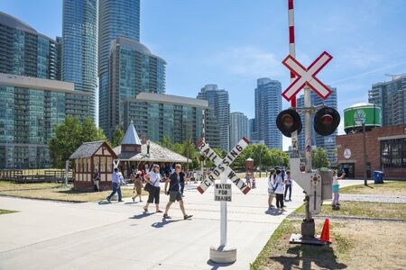 Toronto,Canada-august 2,2015:people visit the  Toronto's railway heritage center with a view of skyscrapers during a sunny dayのeditorial素材