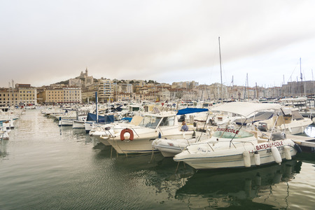 Marseilles,France-august 10,2016:boats moored in the port of Marseilles in France on a sunny day with a striking sky full of smoke from a nearby fireのeditorial素材